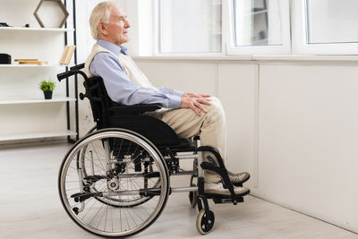 Side view of man sitting on floor