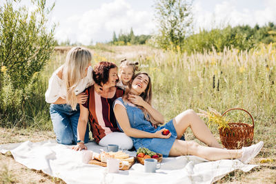 The family is having a picnic on the lawn. three generations of women of the same family 