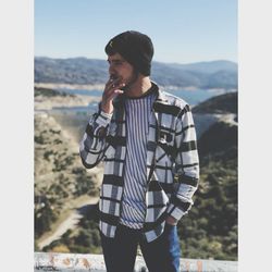 Young man standing on land against mountains