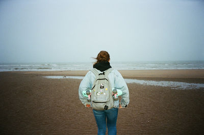 Man standing on beach against clear sky