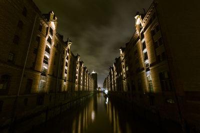 Street amidst buildings in city at night
