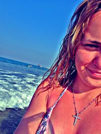 Close-up of beautiful woman against sea against clear sky