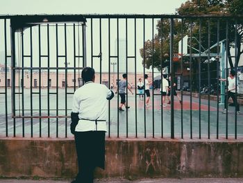 Rear view of man watching basket ball in university