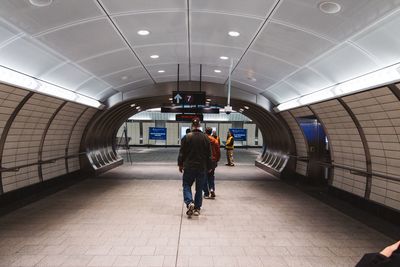 Rear view of woman walking in tunnel