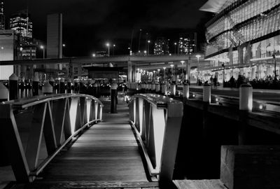 Empty chairs and tables in illuminated building at night