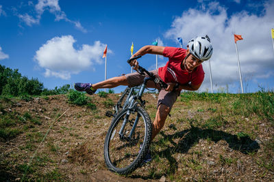 Man cycling on bicycle against sky