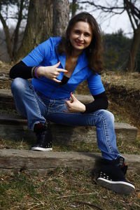 Portrait of smiling young woman sitting on land