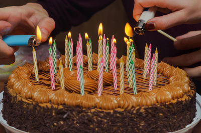 Lighting candles on a birthday cake. 33 candles.