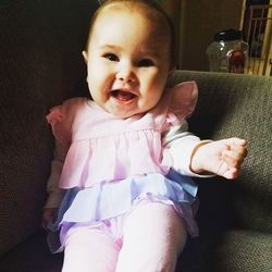 Portrait of cute baby girl sitting at home