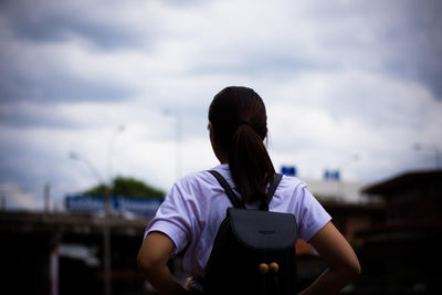 Rear view of woman standing against sky