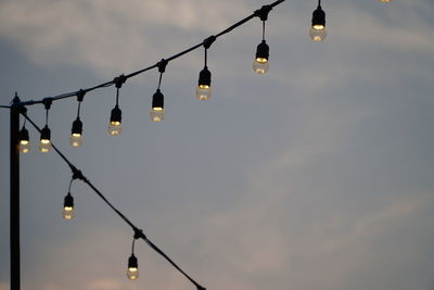 Low angle view of illuminated street light against sky