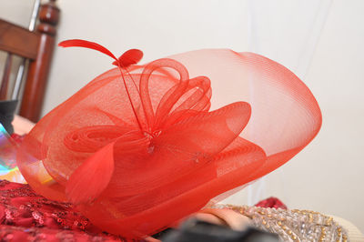 Close-up of woman holding red flower at home