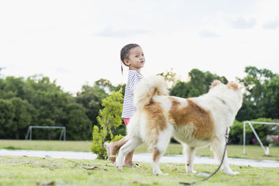 Portrait of cute girl with dog on field