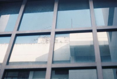 Low angle view of building seen through glass window