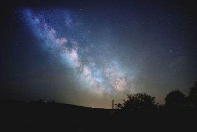 Low angle view of silhouette trees against sky at night