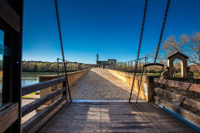 Walkway against clear blue sky