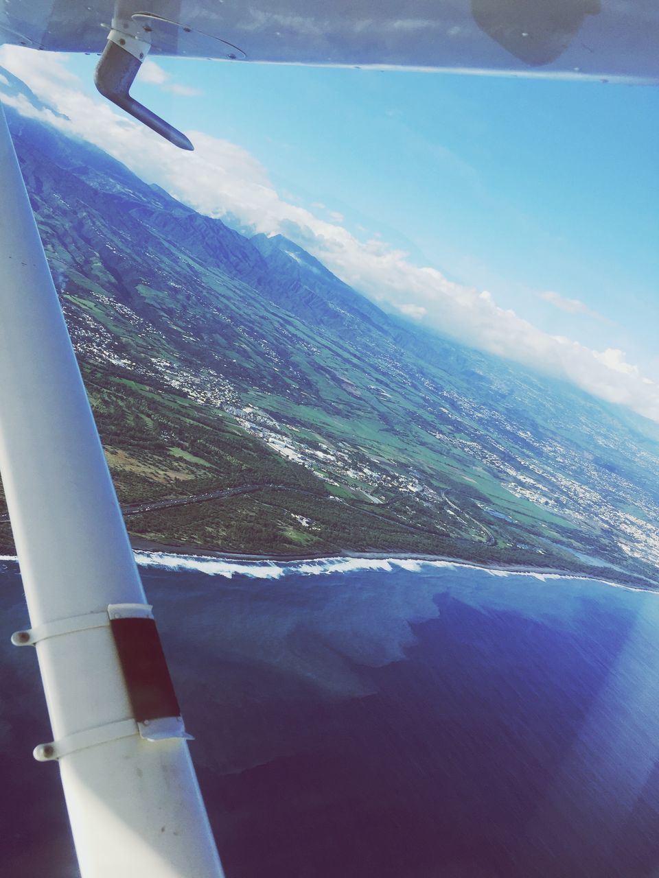 sea, aerial view, airplane, air vehicle, water, flying, aircraft wing, sky, transportation, mode of transport, scenics, horizon over water, built structure, travel, architecture, cityscape, city, blue, building exterior, mid-air