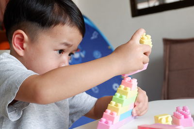 Close-up of boy playing with toys at home