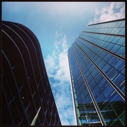 Low angle view of modern building against cloudy sky