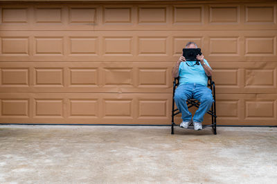 Side view of man standing against wall