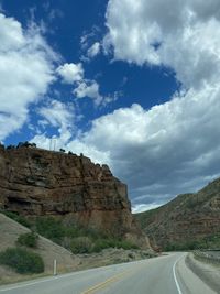 Road leading towards mountains against sky