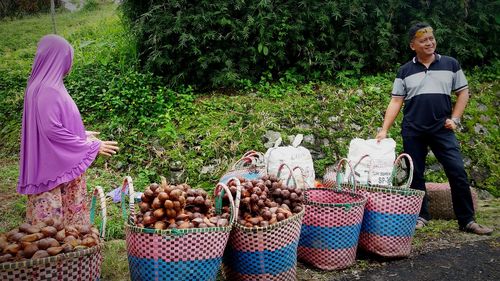 Portrait of woman standing by basket on field