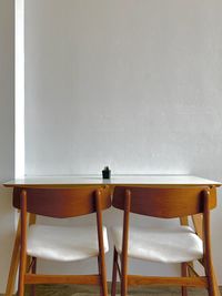 Empty chairs and table against wall at home