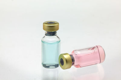 Close-up of glass bottle on table against white background