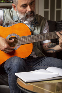 Modern bearded man taking guitar lessons online. online learning concept.