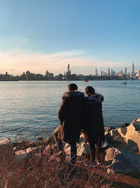 Rear view of man and woman in city against sky