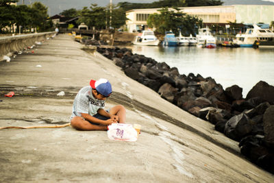 Full length of boy sitting on shore