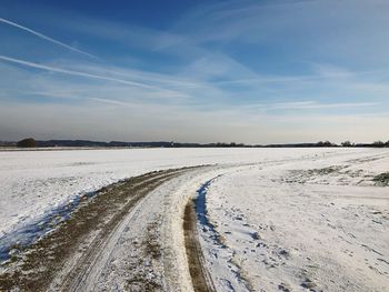 Scenic view of road against sky during winter