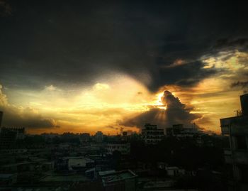 Buildings against cloudy sky at sunset