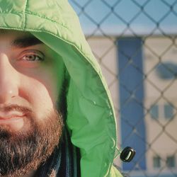 Close-up portrait of man wearing fence