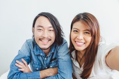 Portrait of a smiling young woman against white background