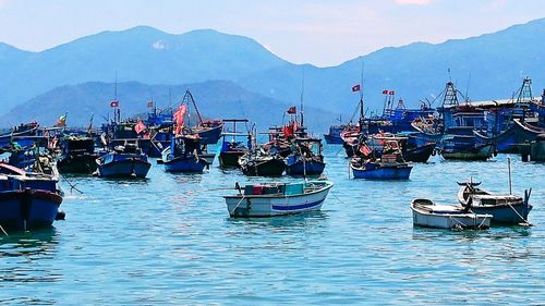 Boats moored in sea against sky