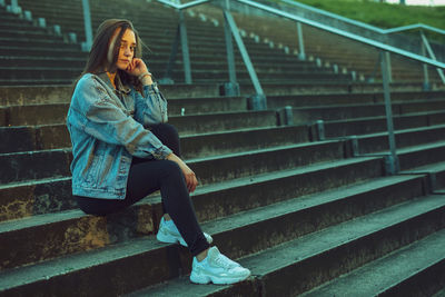 Portrait of young woman sitting on staircase