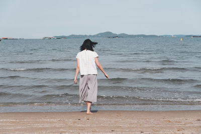 Rear view of woman standing on beach