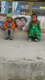 Full length portrait of happy friends sitting outdoors