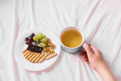 High angle view of woman holding breakfast on table