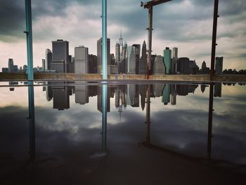 Manhattan skyline reflection in puddle at brooklyn bridge park