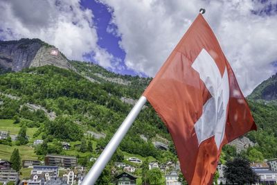 Low angle view of flag on mountain against sky