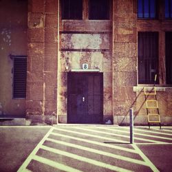 Road marking by closed door of old building