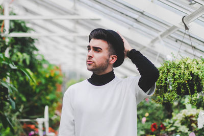 Mid adult man standing in greenhouse