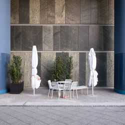 Empty chairs and table against wall in building