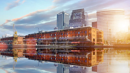 Reflection of buildings in river against sky