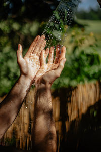 Close-up of hand holding leaf against blurred background