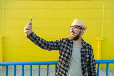 Portrait of young man standing against wall