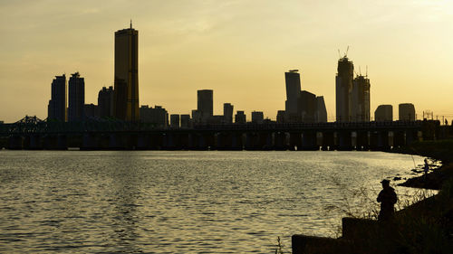 View of modern buildings in city at sunset