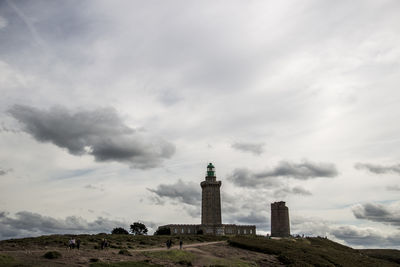 Lighthouse by sea against sky